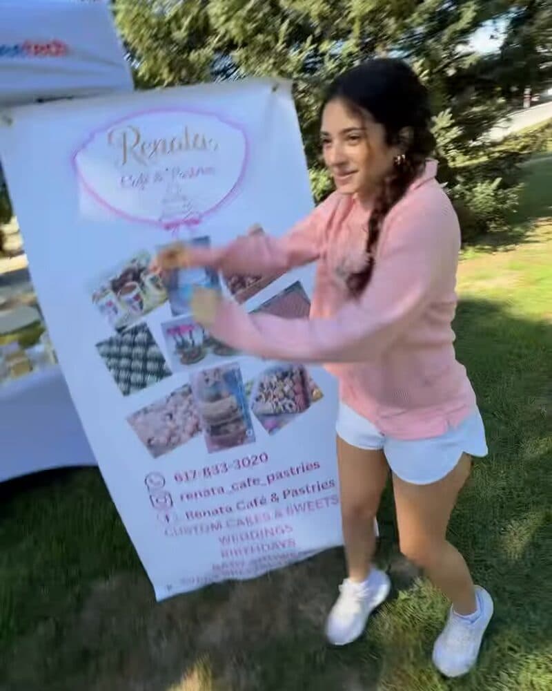 Dancing next to the Renata Café & Pastries banner at Safford Park